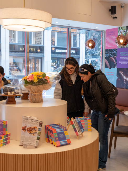 Two people looking at products on a display table in a store.